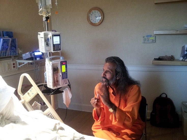 Swami visiting with a patient in the hospital who had requested time with him.
